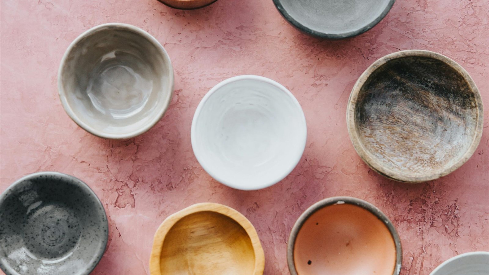 Handmade ceramic bowls arranged on a linen table